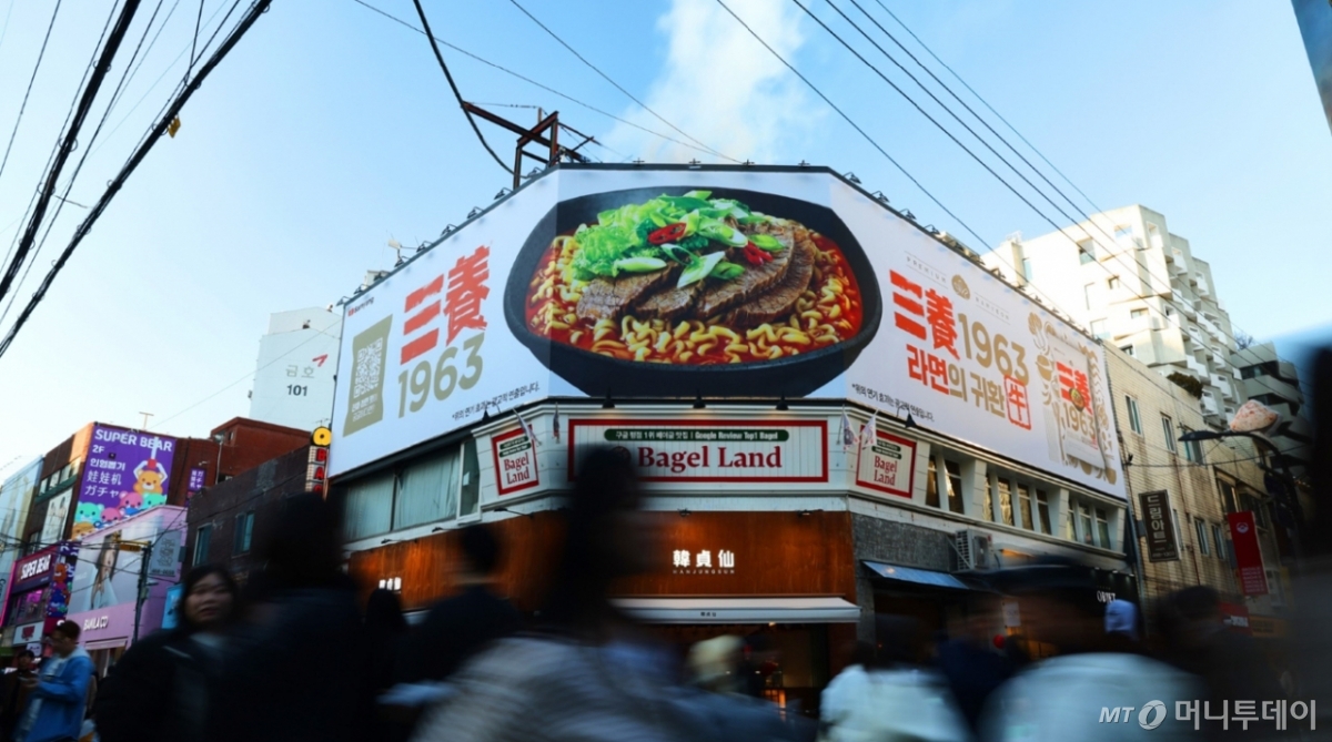 [서울=뉴시스] 황준선 기자 = 삼양식품이 신제품 '삼양1963' 출시를 기념해 19일부터 오는 26일까지 서울 성동구 성수동에서 옥외광고 캠페인을 진행한다고 밝혔다. '삼양1963'은 삼양브랜드를 통해 처음으로 선보이는 프리미엄 미식 라면으로 과거 삼양라면 제조 레시피의 핵심이었던 우지를 활용해 면의 고소한 맛과 국물의 깊은 맛을 끌어올려 차별화된 풍미를 구현했다. (사진=삼양식품 제공) 2025.11.19. *재판매 및 DB 금지