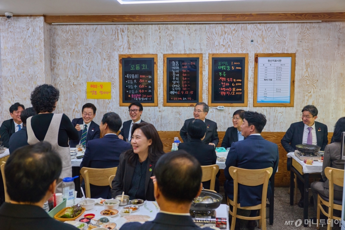 [서울=뉴시스] 이재명 대통령이 23일 부산진구 부전시장 내 한 횟집을 찾아 국무위원, 대통령실 직원들과 함께 오찬을 하며 상인과 대화를 하고 있다. (사진=대통령실 제공) 2025.12.23. photo@newsis.com *재판매 및 DB 금지 /사진=