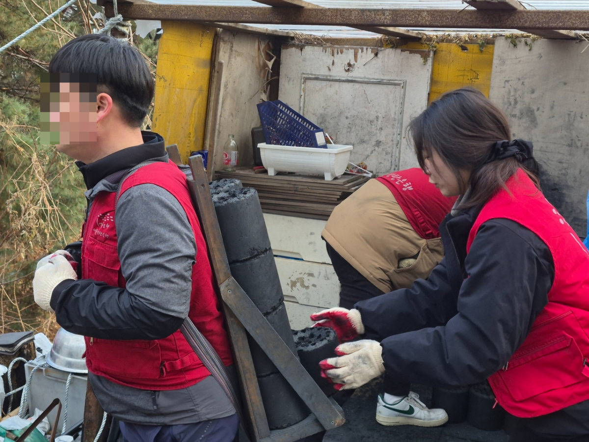 기자가 연탄을 비축창고에 쌓아두기 위한 적재 작업을 하고 있다. /사진제공=밥상공동체.