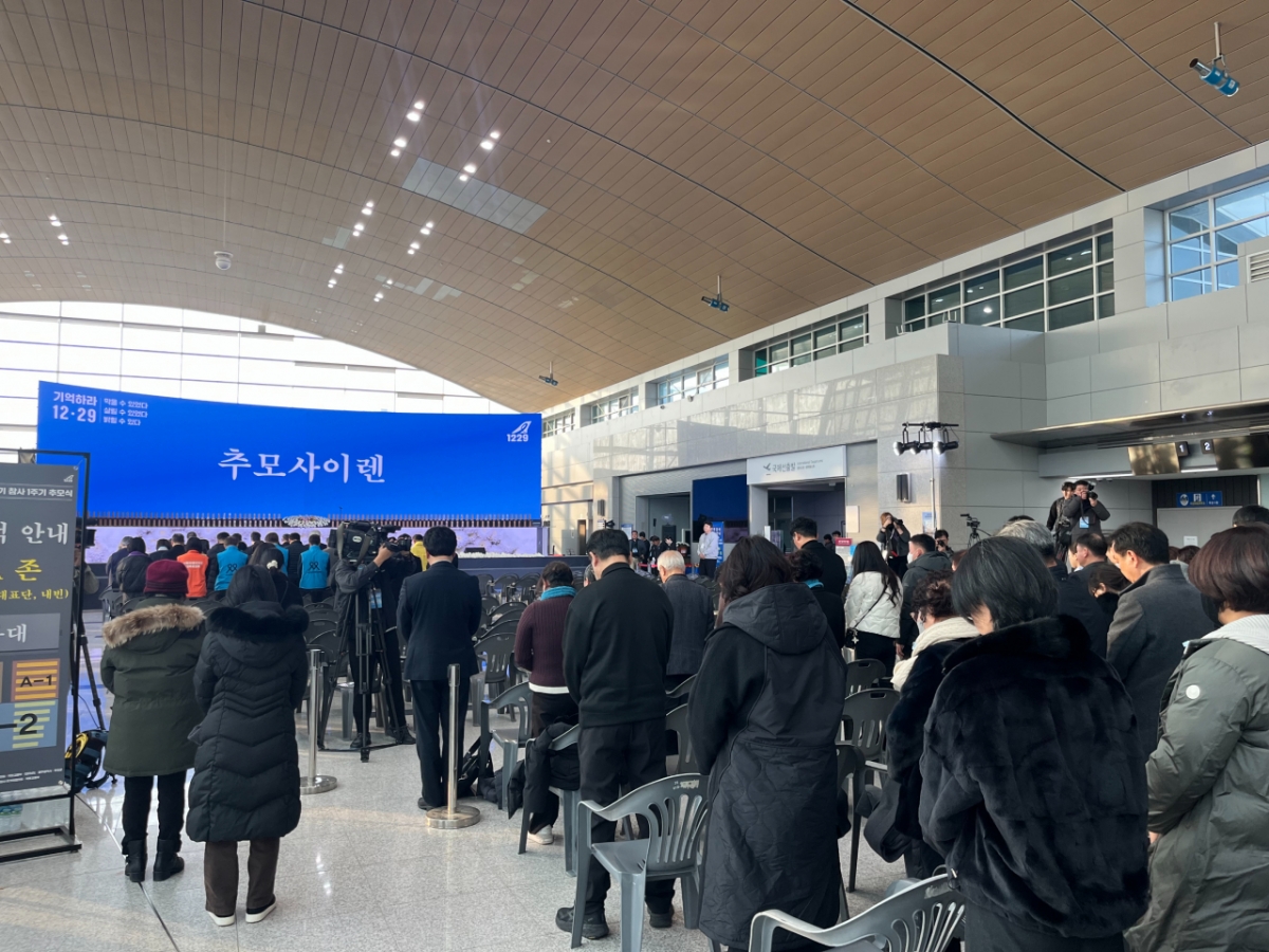 29일 오전 9시3분 전남 무안군 무안국제공항 2층에서 추모 사이렌이 울려퍼지자 시민들이 묵념하고 있다./사진=이정우 기자.