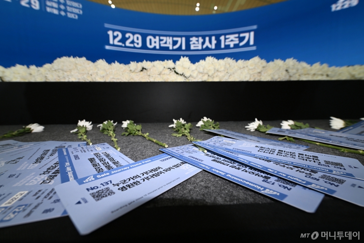 [무안=뉴시스] 이영주 기자 = 29일 오전 전남 무안국제공항에서 거행된 12·29 제주항공 참사 추모식의 제단 위로 참사 재발 방지를 염원하는 유가족들의 바람이 담긴 보딩패스 형식 메시지와 국화가 놓여있다. 2025.12.29. leeyj2578@newsis.com /사진=이영주
