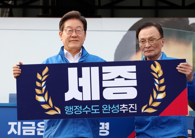 ▲이재명 당시 더불어민주당 대선후보가 지난해 5월 31일 오후 세종시 나성동 나무그늘광장에서 열린 유세에서 이해찬 상임고문과 함께 ‘세종 행정수도 완성 추진’이라고 적힌 패널을 들고 있다./사진=뉴시스