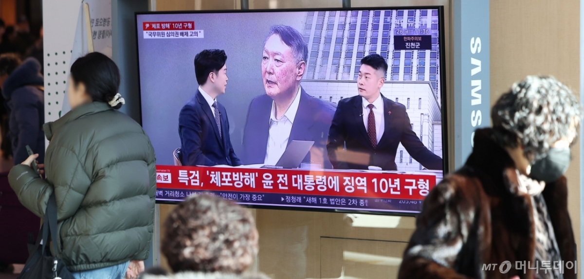 [서울=뉴시스] 김선웅 기자 = 26일 서울역 대합실에 설치된 TV에서 윤석열 전 대통령에 대한 체포 방해 및 국무위원 계엄 심의·의결권 침해 등 혐의 사건 결심공판 뉴스 영상이 송출되고 있다.   조은석 내란 특별검사팀이 윤 전 대통령을 기소한 4개의 내란 재판 중 처음으로 변론이 종결된 이날 결심공판에서 특검은 징역 10년을 구형했다. 2025.12.26. mangusta@newsis.com /사진=김선웅