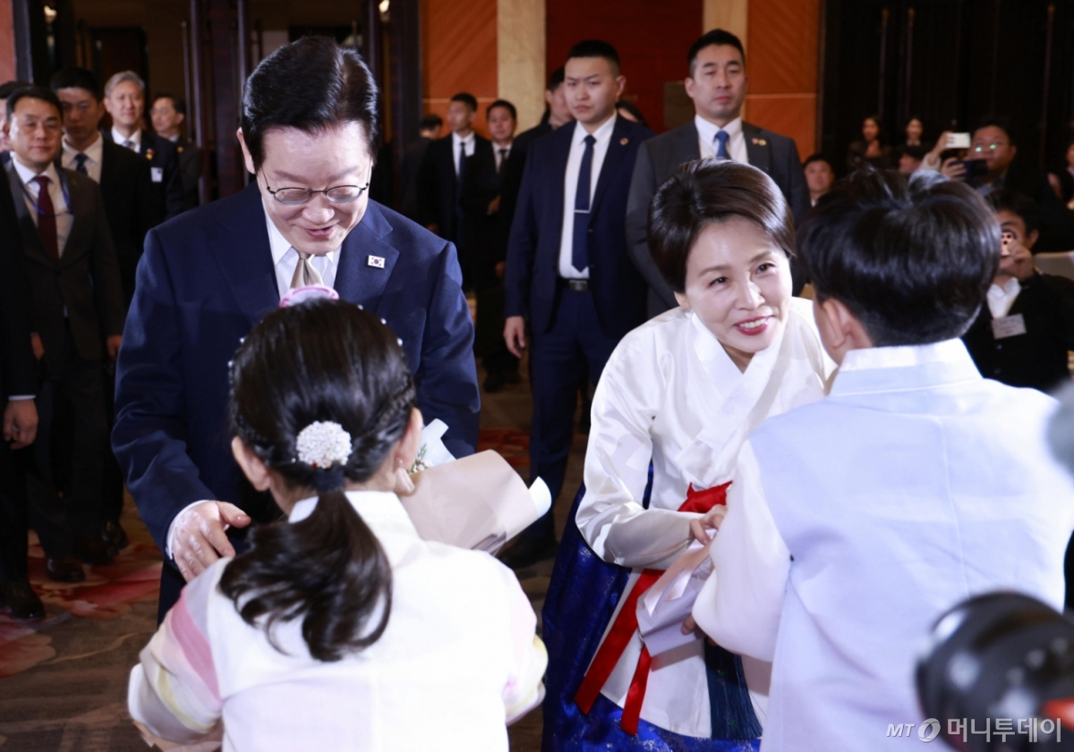 (베이징(중국)=뉴스1) 허경 기자 = 중국을 국빈 방문 중인 이재명 대통령과 김혜경 여사가 4일 베이징 한 호텔에서 열린 재중 한국인 간담회에서 화동에게 꽃다발을 받고 있다. 2026.1.4/뉴스1  Copyright © 뉴스1. All rights reserved. 무단 전재 및 재배포,  AI학습 이용 금지. /사진=(베이징(중국)=뉴스1) 허경 기자