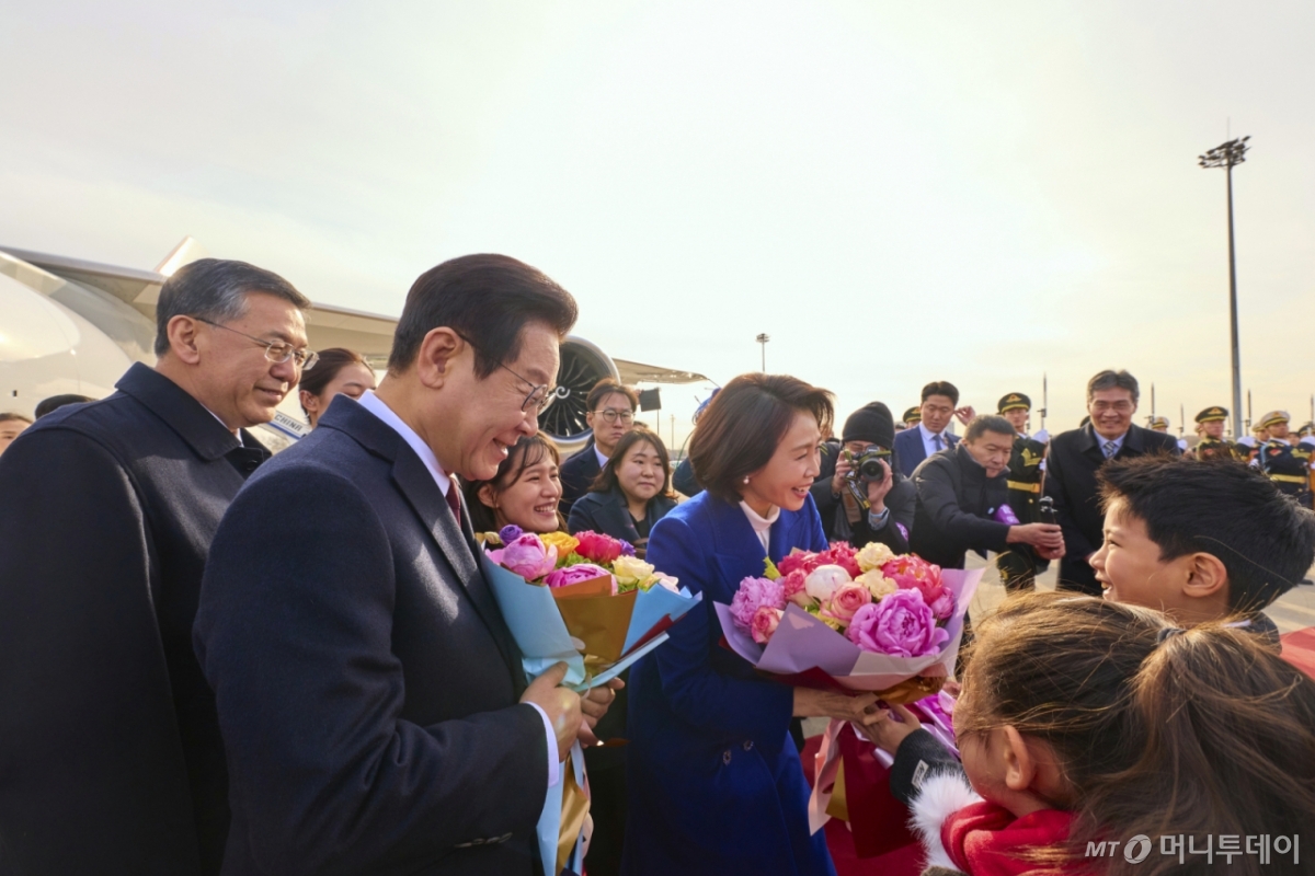 (베이징(중국)=뉴스1) 허경 기자 = 중국을 국빈방문하는 이재명 대통령과 김혜경 여사가 4일 베이징 서우두 공항에서 화동들에게 꽃다발을 전달 받고 있다. (공동취재) 2026.1.4/뉴스1  Copyright © 뉴스1. All rights reserved. 무단 전재 및 재배포,  AI학습 이용 금지. /사진=(베이징(중국)=뉴스1) 허경 기자