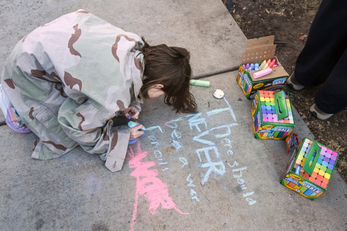 4일(현지 시간) 미 콜로라도주 콜로라도스프링스 시청 앞에서 열린 니콜라스 마두로 베네수엘라 대통령 부부 체포에 항의하는 시위에서 한 소녀가 인도에 "석유 때문에 전쟁 일어나면 안 돼"라고 적고 있다./AP=뉴시스