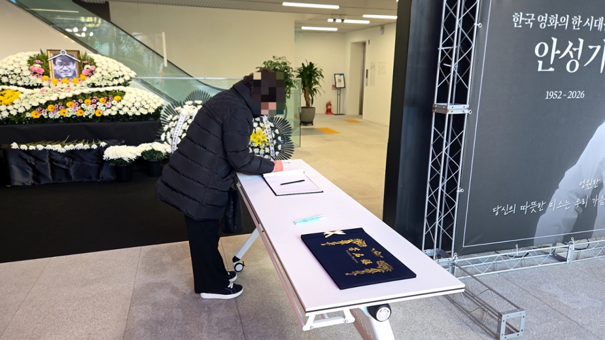 6일 오전 한 시민이 배우 안성기의 추모 공간에 놓인 방명록에 글을 쓰는 중이다./사진=김서현 기자. 
