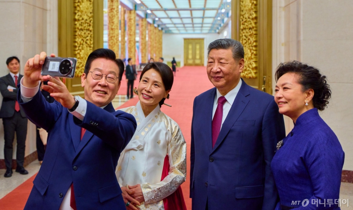 중국을 국빈 방문 중인 이재명 대통령과 김혜경 여사가 5일(현지 시간) 베이징 인민대회당에서 열린 공식만찬을 마친 뒤 시진핑 국가주석, 부인 펑리위안 여사와 경주 정상회담에서 시 주석에게 선물 받은 샤오미폰으로 셀카를 찍고 있다. / 사진=뉴시스