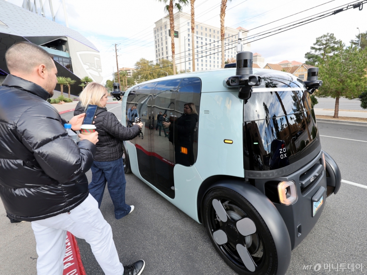 (라스베이거스(미국)=뉴스1) 황기선 기자 = 세계 최대 IT(정보기술)·가전 전시회 'CES 2026' 개막을 이틀 앞둔 4일(현지시간) 미국 네바다주 라스베이거스 거리에서 시민들이 아마존의 로보택시 '죽스(ZOOX)'를 바라보고 있다. 이 자율주행 택시는 운전자는 물론 스티어링휠과 페달, 계기반 등이 아예 없는 것이 특징이다.  2026.1.5/뉴스1  Copyright © 뉴스1. All rights reserved. 무단 전재 및 재배포,  AI학습 이용 금지. /사진=(라스베이거스(미국)=뉴스1) 황기선 기자