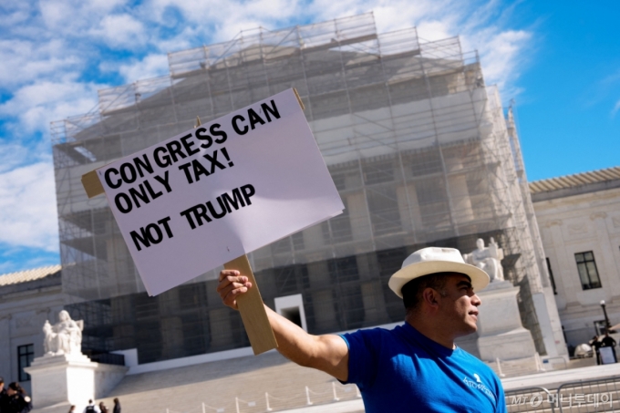 지난해 11월5일(현지시간) 워싱턴DC 연방대법원 앞에서 한 활동가가 '세금은 의회만 부과할 수 있다! 트럼프는 아니다'라는 문구가 적힌 피켓을 들고 있다. 대법원은 이날 도널드 트럼프 미국 대통령이 국제비상경제권법(IEEPA)에 의거해 부과한 상호관세의 적법성을 따질 최종심의 심리를 개시했다. /워싱턴DC AFP=뉴스1