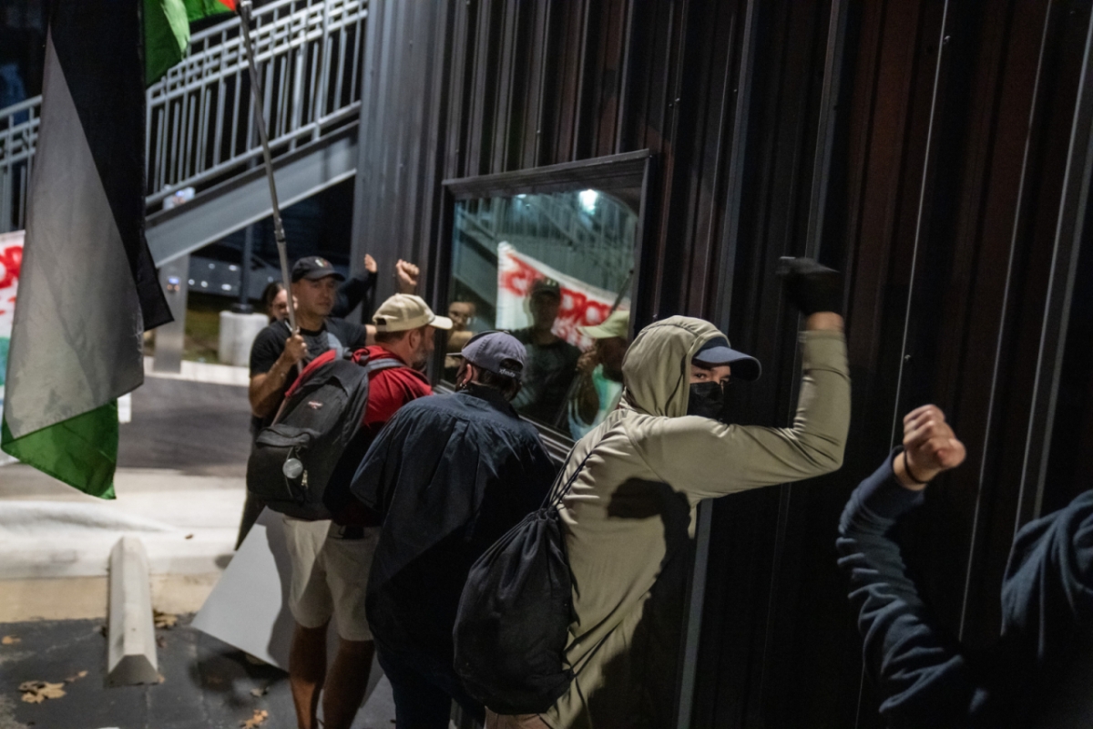 [플루거빌=AP/뉴시스] 8일(현지 시간) 미 텍사스주 플루거빌에서 전날 미네소타주 미니애폴리스에서 이민세관단속국(ICE) 요원의 총격으로 사망한 르네 니콜 굿 사건에 항의하는 시위대가 현지 ICE 시설 벽을 두드리며 철수를 요구하고 있다. 