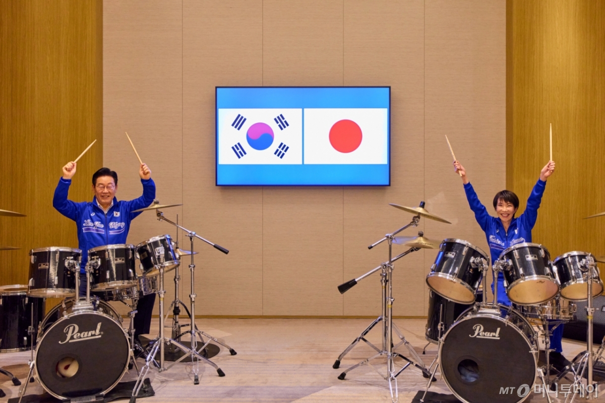 [나라=뉴시스] 고범준 기자 = 이재명 대통령이 다카이치 사나에 일본 총리와 함께 13일(현지 시간) 일본 나라현 회담장에서 일본 측이 마련한 푸른색 유니폼을 함께 착용하고 일본의 대표적인 악기 브랜드인 '펄' 드럼 앞에 나란히 앉아 즉석 드럼 합주를 선보이고 있다. (공동취재) 2026.01.13. 
