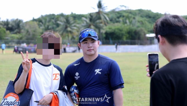 문현빈(오른쪽)이 사이판 훈련 현장을 찾은 한화 팬과 기념촬영을 하고 있다. /사진=강영조 선임기자