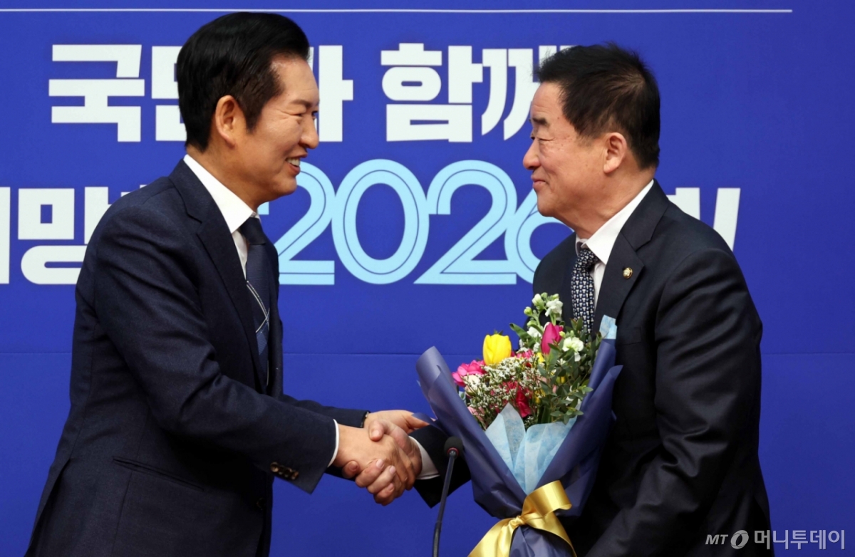 [서울=뉴시스] 조성봉 기자 = 정청래 더불어민주당 대표가 12일 오전 서울 여의도 국회에서 열린 최고위원회의에서 강득구 최고위원에게 꽃다발을 전달하고 악수를 하고 있다.  2026.01.12. suncho21@newsis.com /사진=조성봉