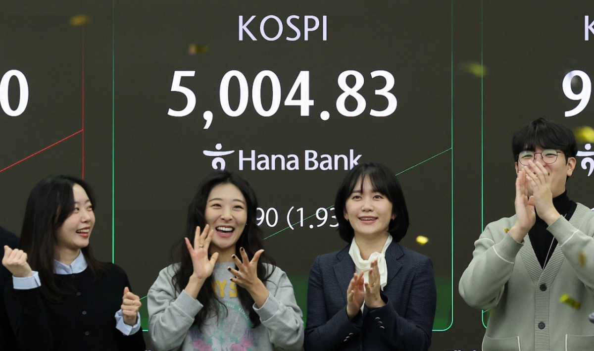 (서울=뉴스1) 박지혜 기자 = 22일 오전 서울 중구 하나은행 본점 딜링룸 현황판에 코스피 지수가 장중 5000p를 넘으며 개장하자 직원들이 환호하고 있다. 2026.1.22/뉴스1  Copyright © 뉴스1. All rights reserved. 무단 전재 및 재배포,  AI학습 이용 금지. /사진=(서울=뉴스1) 박지혜 기자