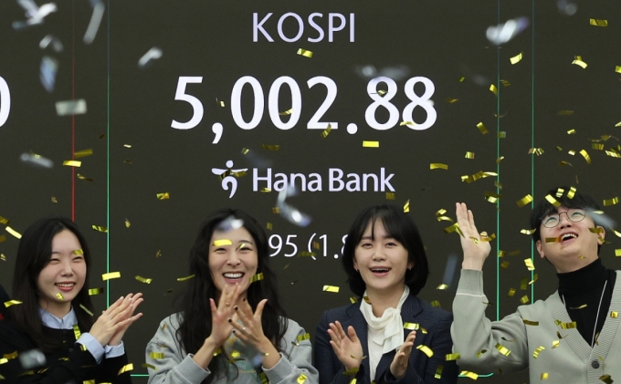 코스피지수가 사상 처음으로 장중 5000을 돌파한 22일 오전 서울 을지로 하나은행 딜링룸에서 직원들이 신기록 달성을 축하하고 있다/사진=뉴스1