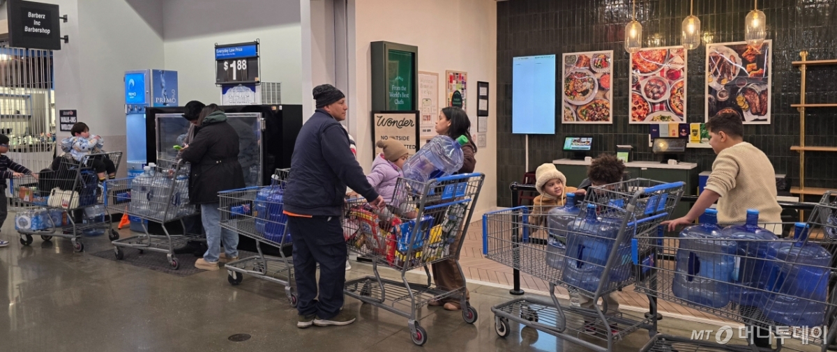 24일(현지시간) 미국 뉴저지주 월마트 매장에서 생수통에 물을 받으려는 사람들이 줄을 서 있다. /사진=심재현 특파원