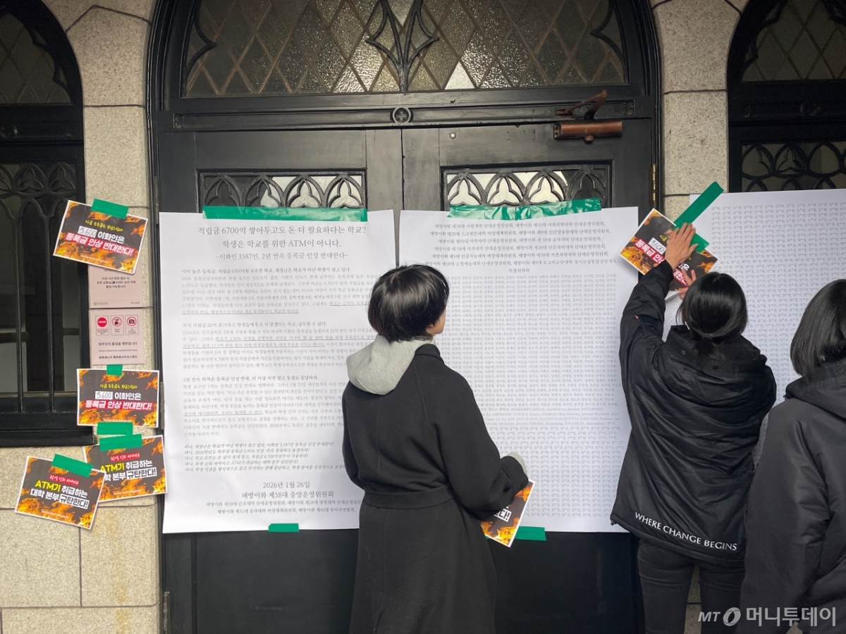 26일 이화여대 학생들이 등록금 인상 반대 성명문을 학교 본관 앞에 붙이는 퍼포먼스를 하고 있다./사진=이현수 기자.