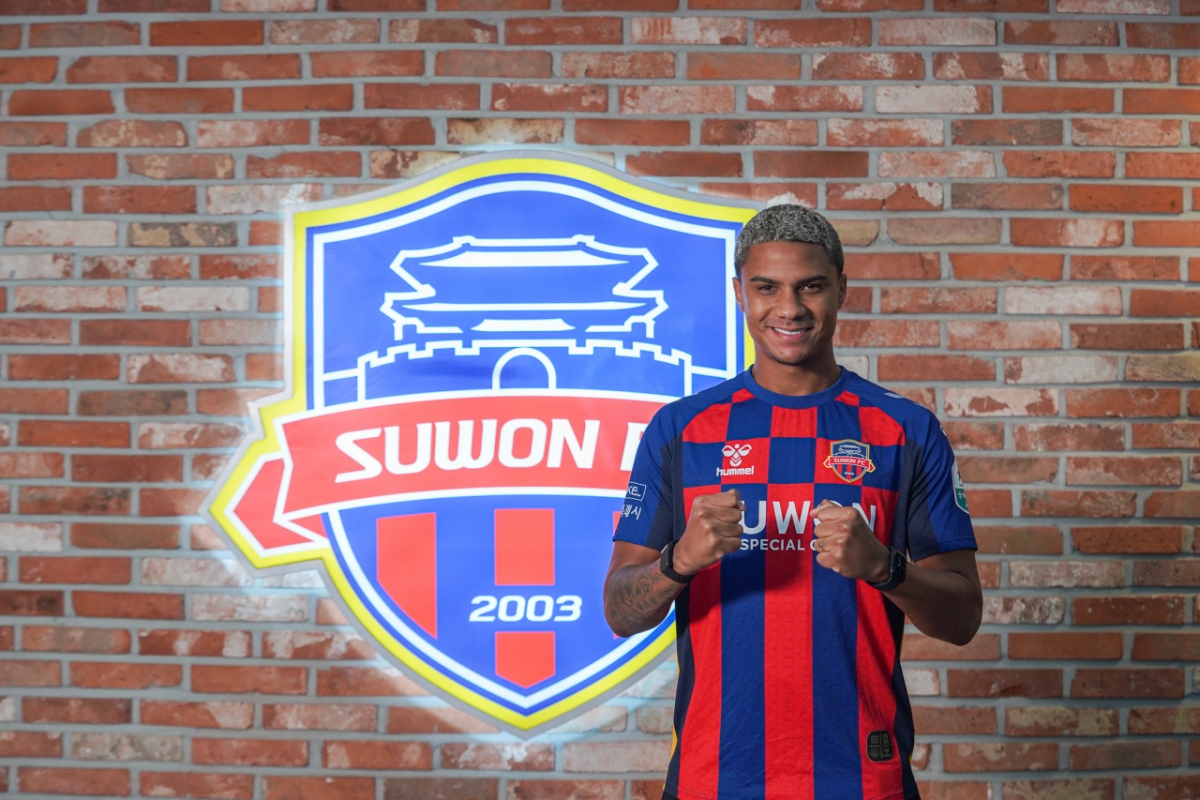 델란이 수원FC 앰블럼 앞에서 포즈를 취하고 있다. /사진=수원FC 제공