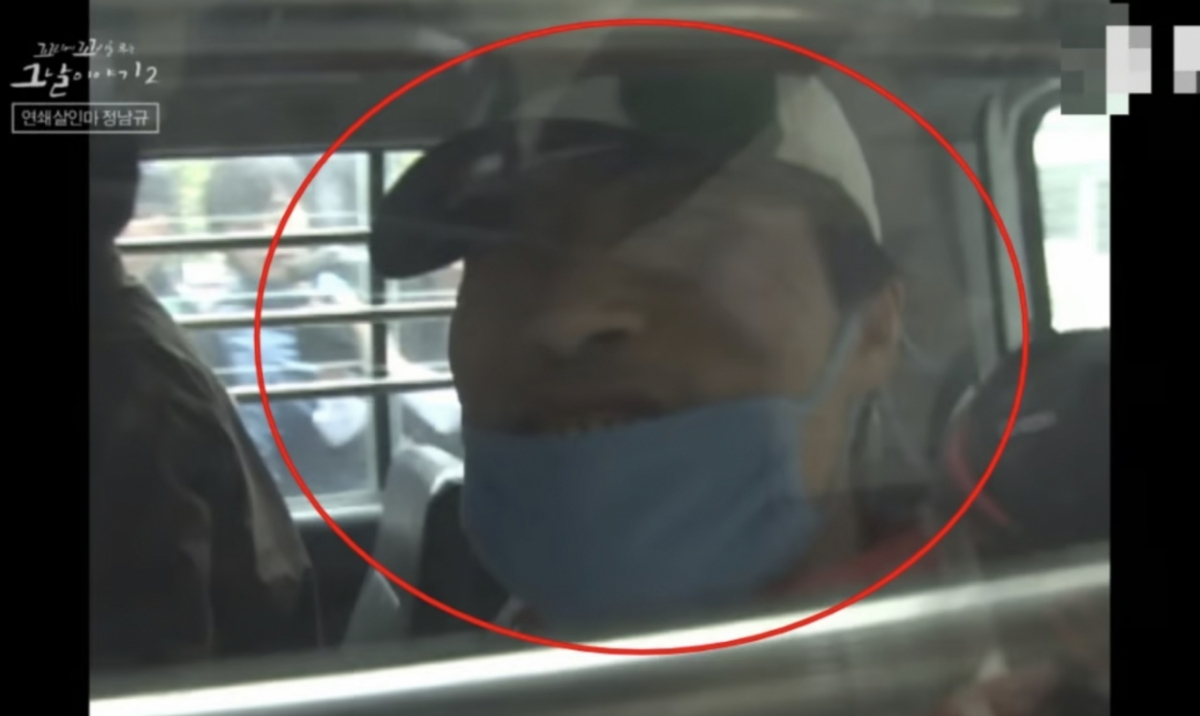 경찰 호송차 안에서 자신을 촬영하는 방송국 카메라를 보며 웃는 연쇄살인범 정남규 모습. /사진=SBS 교양 공식 유튜브 채널 '달리' 갈무리 