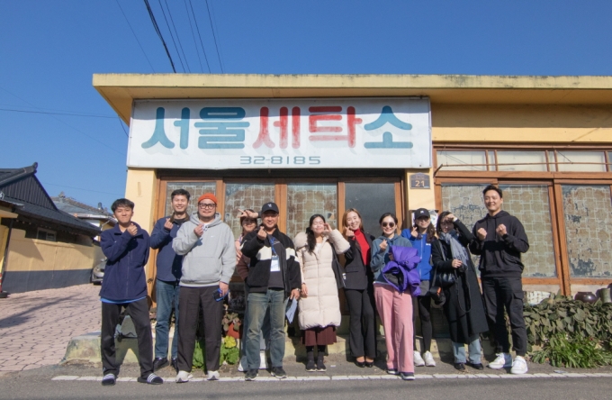 ▲ 2024년 12월, 청춘어람 워케이션 프로그램 참가자들이 동네 빈집을 활용한 포토존 ‘서울세탁소’에서 사진을 남기고 있다./사진제공=청춘어람 