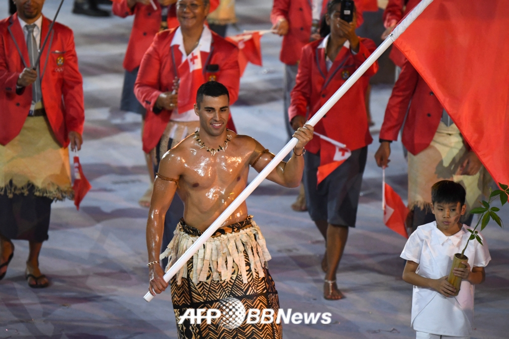 '통가 근육맨' 피타 타우파토푸아(오른쪽)가 2018 평창 올림픽 개회식 당시 기수로 나선 모습. /AFPBBNews=뉴스1