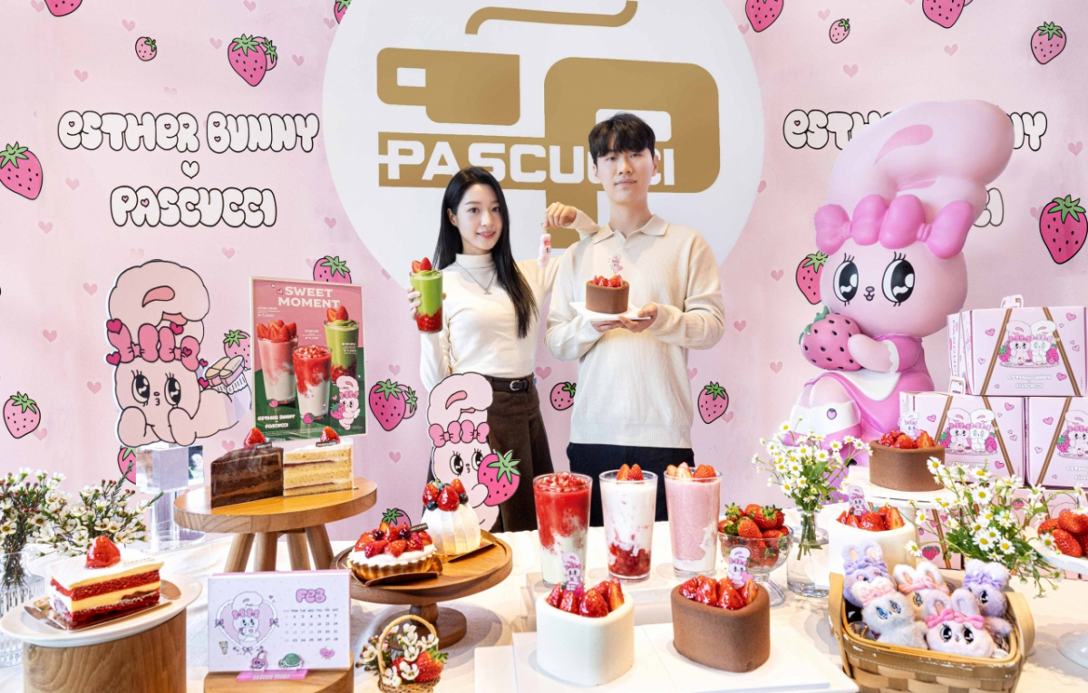 서울 중구 파스쿠찌 센트로서울점에서 모델이 에스더버니 하트 모양 딸기 케이크와 음료를 들어 보이고 있다. 파스쿠찌는 에스더버니 협업을 기념해 센트로서울점과 센트로서면점을 핑크 무드의 비주얼 점포로 꾸몄다.