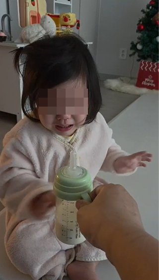 우유 먹을 시간에 우유를 줬더니 자신이 요청하기도 전에 준 사실에 분개하며 손사래를 치고 있는 아이. /사진=최우영 기자