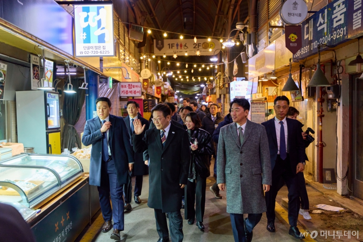 [서울=뉴시스] 최동준 기자 = 이재명 대통령이 9일 서울 종로구 통인시장을 방문해 상인들과 인사하고 있다.  이번 일정은 최근 일부 경제지표가 개선되는 흐름을 보이고 있지만 장바구니 물가 등 체감경기가 여전히 어렵다는 국민들의 목소리를 현장에서 직접 듣기 위해 마련됐다. (사진=청와대 제공) 2026.02.09. photo@newsis.com *재판매 및 DB 금지 /사진=