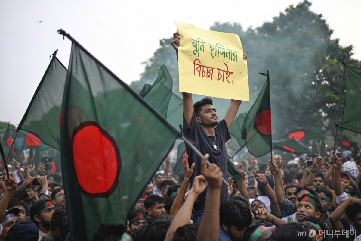 [다카=AP/뉴시스] 5일(현지 시간) 방글라데시 다카에서 대학생들과 주민들이 국기를 들고 ‘7월 봉기’(2024) 1주년을 기념하고 있다. 2024년 7월 공무원 할당제 반대 시위로 시작된 학생 시위는 정부의 강경 진압으로 반정부·반독재 투쟁으로 확대됐고, 8월 5일 수천 명의 시위대가 총리 관저를 점령하면서 당시 셰이크 하시나 총리가 퇴진해 인도로 망명했다. ‘7월 봉기’는 방글라데시 현대 정치사에서 최대 규모의 반정부 봉기로 평가받는다. 2025.08.06. /사진=민경찬