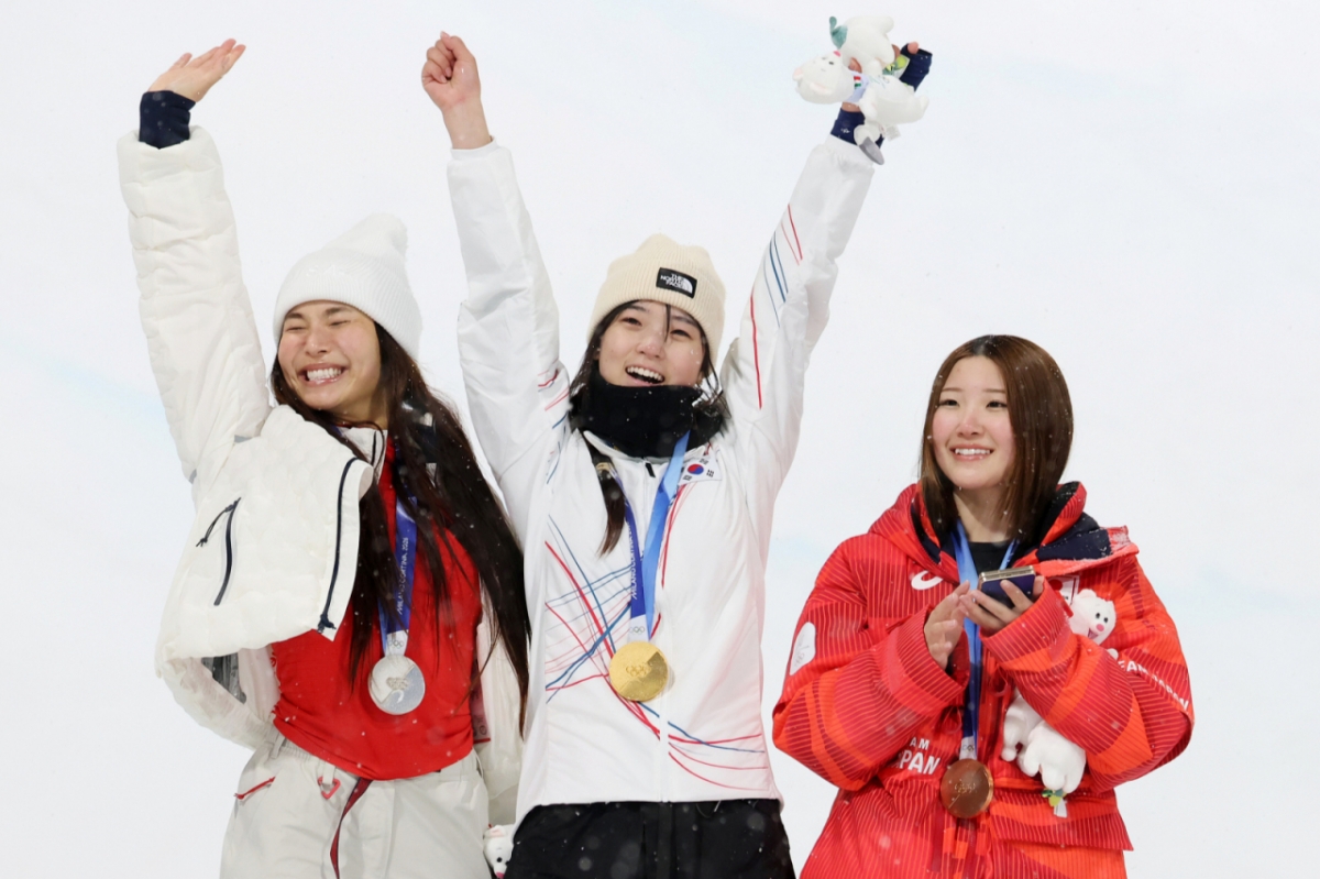이탈리아 리비뇨 스노파크에서 12일(현지시간) 열린 '2026 밀라노·코르티나담페초 동계올림픽' 스노보드 여자 하프파이프 종목에서 금메달을 따낸 대한민국의 최가온(가운데)이 기뻐하고 있다. /사진=뉴스1