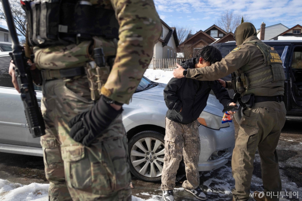미국 연방 요원들이 지난 1월12일(현지시간) 미네소타주 미니애폴리스에서 주택가에 서 있던 한 남성을 체포하고 있다. /미니애폴리스 AFP=뉴스1