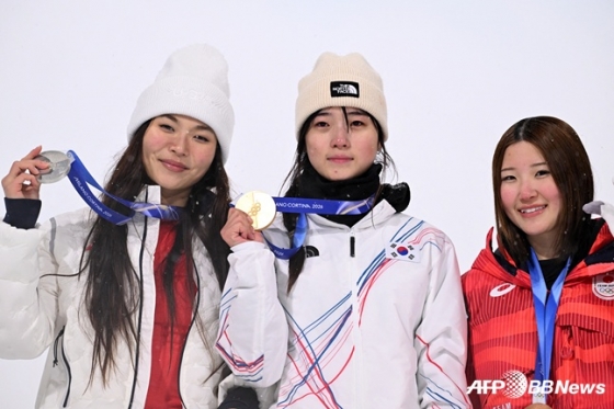 최가온(가운데)이 13일(현지시간) 이탈리아 리비뇨 스노파크에서 열린 2026 밀라노·코르티나담페초 동계올림픽 스노보드 여자 하프파이프 결선에서 90.25점으로 88.00점의 클로이 김(미국·왼쪽)을 제치고 시상대에 올라 포즈를 취하고 있다. /AFPBBNews=뉴스1
