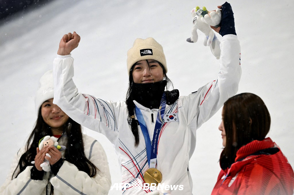 최가온(가운데)이 13일(한국시간) 이탈리아 리비뇨 스노파크에서 열린 2026 밀라노·코르티나담페초 동계올림픽 여자 스노보드 하프파이프 금메달을 차지한 뒤 시상대에서 기뻐하고 있다. 최가온의 이번 금메달은 대회 한국 선수단 첫 금메달이자 한국 스키의 동계올림픽 사상 첫 금메달, 역대 동계 올림픽 스노보드 최연소 금메달이다. /AFPBBNews=뉴스1