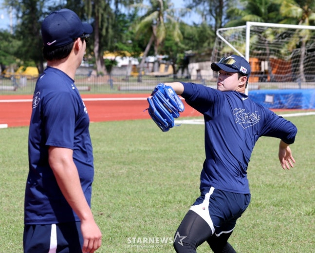 문동주(오른쪽)가 캐치볼 훈련을 마치고 원태인에게 조언을 구하고 있다.  /사진=강영조 선임기자