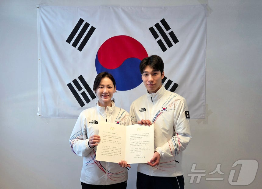 황대헌(오른쪽)이 15일(한국시간) 이탈리아 밀라노에서 이수경 선수단장에게 이재명 대통령 축전을 받은 뒤 기념 촬영을 하고 있다. 왼쪽부터 2026 밀라노·코르티나담페초 동계올림픽 대한민국 선수단 단장 이수경, 쇼트트랙 남자 1500m 은메달리스트 황대헌. /사진=뉴스1 제공