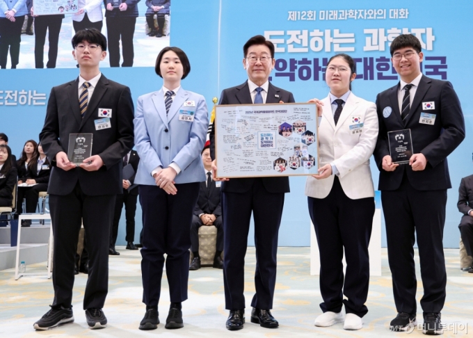 이재명 대통령이 5일 청와대에서 열린 대통령과학장학생·올림피아드 대표단 친수 및 간담회(미래 과학자와의 대화)에서 국제과학올림피아드 대표단에게 우리나라 도약을 이끌 미래 과학자로서 다짐을 담은 기념액자 전달을 받은 뒤 함께 기념촬영을 하고 있다. /사진-뉴시스