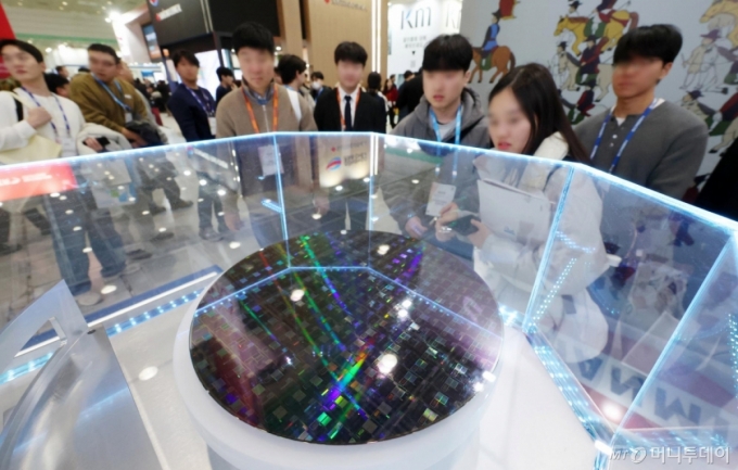 [서울=뉴시스] 조성우 기자 = 11일 오후 서울 강남구 코엑스에서 열린 세미콘 코리아 2026를 찾은 관람객들이 반도체 웨이퍼를 살펴보고 있다. 2026.02.11. xconfind@newsis.com /사진=조성우