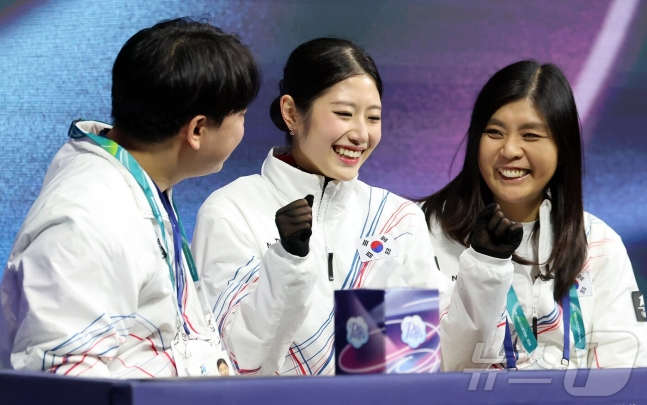 이해인(가운데)이 키스 앤드 크라이 존에서 점수를 확인한 뒤에 코치진들과 함께 환하게 웃고 있다. /사진=뉴스1