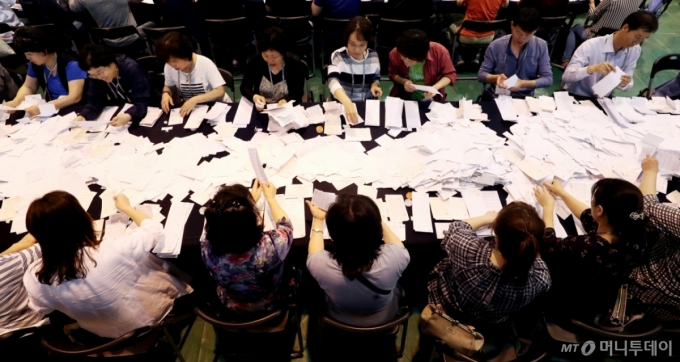 제7회 전국 동시 지방선거 및 교육감 선거, 국회의원 재·보궐 선거가 끝난 13일 오후 서울 서대문구 명지전문대학에 마련된 개표소에서 관계자들이 투표용지를 분류하고 있다. /사진=김창현 기자 chmt@