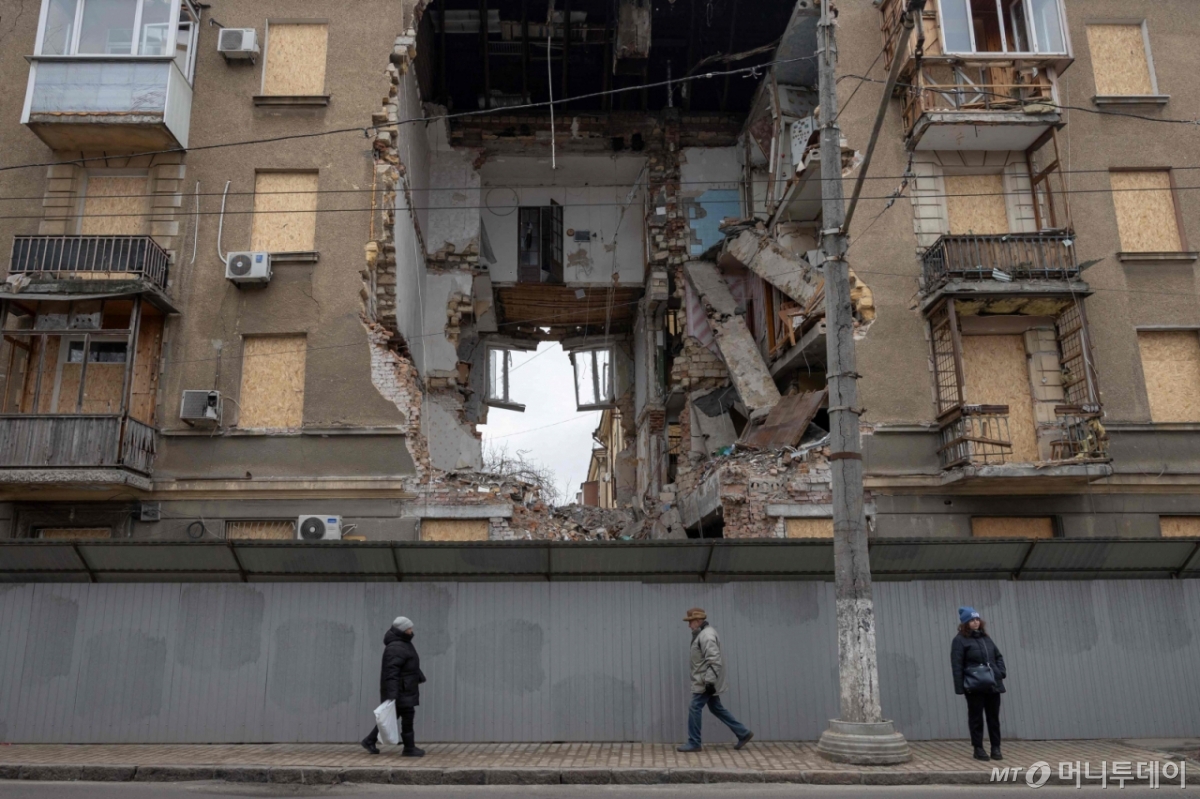 17일(현지시간) 우크라이나 오데사에서 러시아군의 공습으로 크게 파손된 건물 앞을 시민들이 지나고 있다. /사진=오데사 AFP=뉴스1
