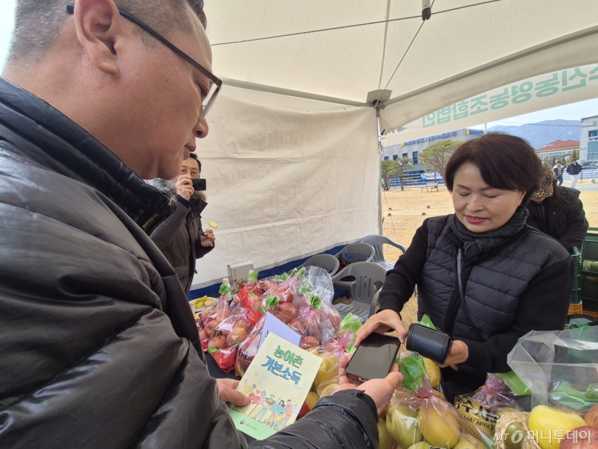 전북 장수군 계북면에서 농어촌 민박을 운영하는 김영섭(51) 씨가 농어촌 기본소득으로 과일을 구입하고 있다. /사진=이수현 