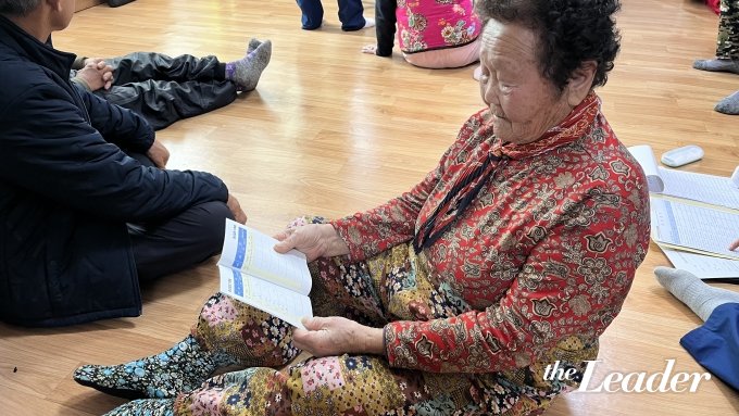 ▲한 어르신이 혈압 수치가 적힌 수첩을 보고 있다./사진=신재은 기자