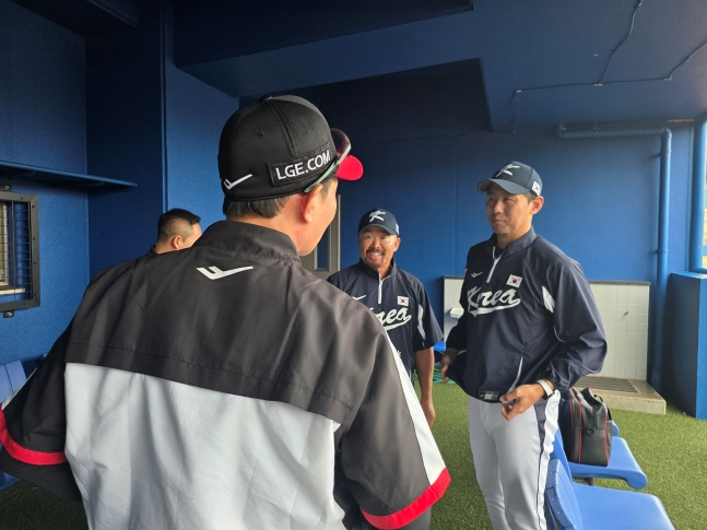 LG 염경엽 감독(왼쪽)이 27일 일본 오키나와현 카데나 구장에서 만난 2026 월드베이스볼클래식(WBC) 국가대표팀 코치로 합류한 김용일 트레이닝 코치(가운데)와 김광삼 투수코치(오른쪽)을 격려했다. /사진=김동윤 기자