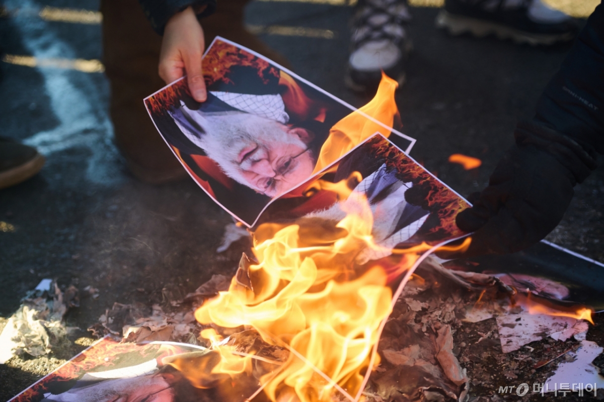 [토론토=AP/뉴시스] 1일(현지 시간) 캐나다 온타리오주 토론토에서 이란 정권 교체를 지지하는 시위대가 아야톨라 알리 하메네이 이란 최고지도자 사진을 불 태우고 있다. 이날 시위대 수천 명이 이란에서 계속되는 경제 위기와 이에 따른 대규모 반정부 시위에 연대해 이슬람 정권의 퇴진을 요구하고 나섰다. 2026.02.02. /사진=민경찬