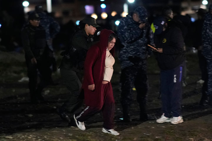 현금 수송기 추락 현장 주변에서 돈을 줍던 한 여성이 경찰에 연행되고 있다/AP=뉴시스