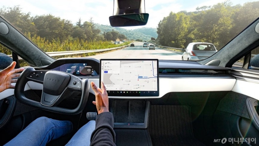 테슬라 모델S 운전자가 자율주행 모드로 도로를 달리고 있다.