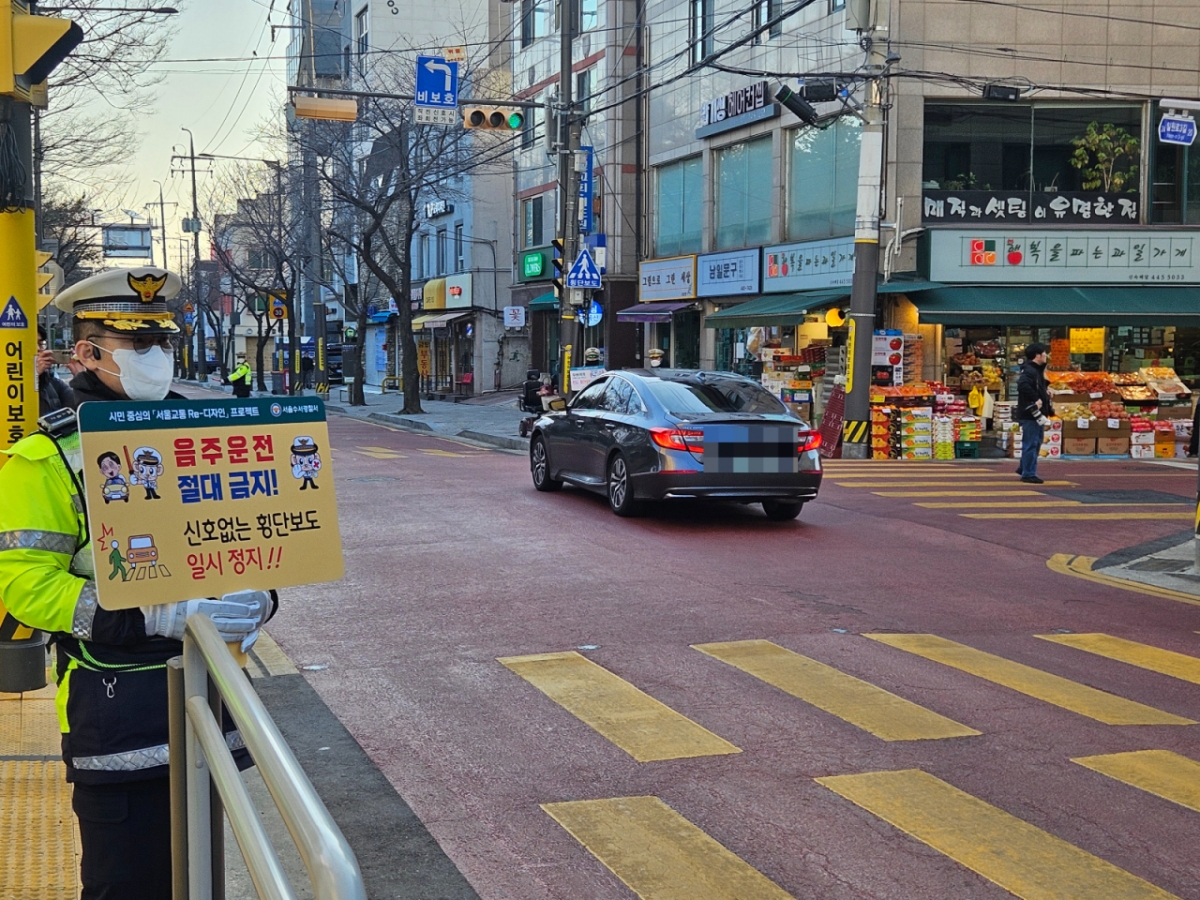 4일 오전 서울 강남구 일원동의 한 초등학교에서 한 경찰관이 음주운전 금지 피켓을 들고 스쿨존 일대에 교통법규 등 위반 단속을 진행하고 있다./사진=박상혁 기자.