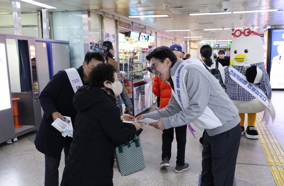 박형준 부산시장(오른쪽)이 부산 도시철도 이용자에게 동백패스·K패스 연계 시행 홍보물을 주고 있다./사진제공=부산시