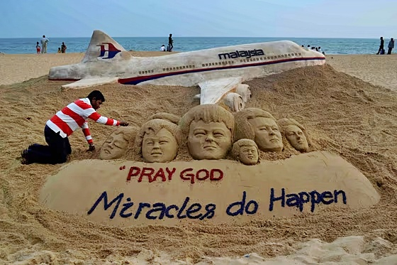 2014년 3월 인도 모래 예술가가 실종된 여객기인 말레이시아 항공 MH370편을 본 딴 모래 조형물과 함께 기적이 일어나길 바란다는 문구를 해변에 새겨 넣고 있는 모습./사진=AFP=뉴스1